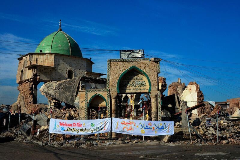 A picture taken on December 16, 2018, shows the Great Mosque of al-Nuri and "Al-Hadba" leaning minaret in Mosul’s war-ravaged Old City, during the placing of the corner stone ceremony. The famed 12th century mosque and minaret, dubbed Al-Hadba or "the hunchback," were where IS chief Abu Bakr al-Baghdadi made his only public appearance to declare a self-styled "caliphate" after sweeping into Mosul in 2014. The structures were ravaged three years later in the final, most brutal stages of the months-long fight against IS.  / AFP / Zaid AL-OBEIDI
