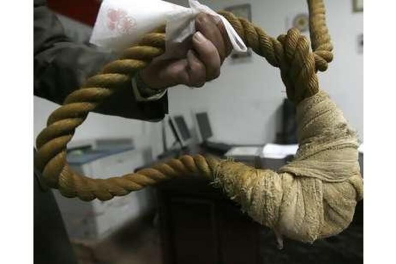 A museum worker shows reporters a noose that will be displayed in a new Iraqi museum in Baghdad.