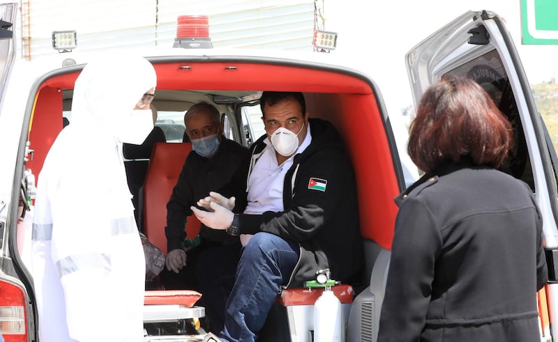 An ambulance transports two Palestinian patients who recovered from Covid-19, in the West Bank city of Nablus.  EPA