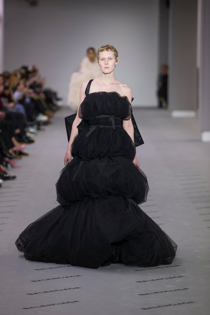 Layers of seemingly untailored black toile have been caught by Balenciaga at the bust, waist, thigh and knee, creating an improbable but theatrical cloud of netting.