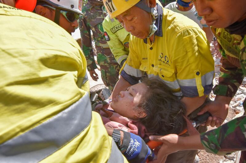 Rescue workers and soldiers carry a woman who was trapped in rubble since Sunday's earthquake. Antara Foto