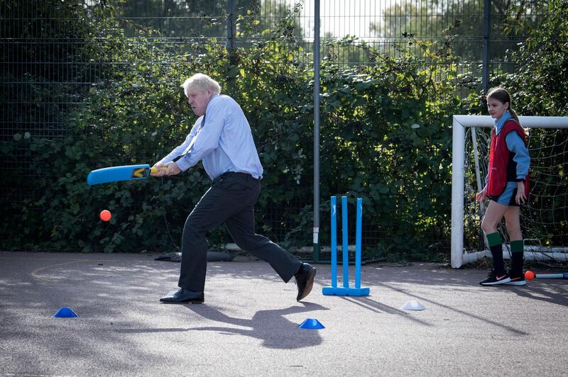 Britain's Prime Minister Boris Johnson takes part in a game of cricket in a sports lesson during a visit to Ruislip High School in his constituency of Uxbridge, west London, on September 28. Stefan Rouseau/PA via AP
