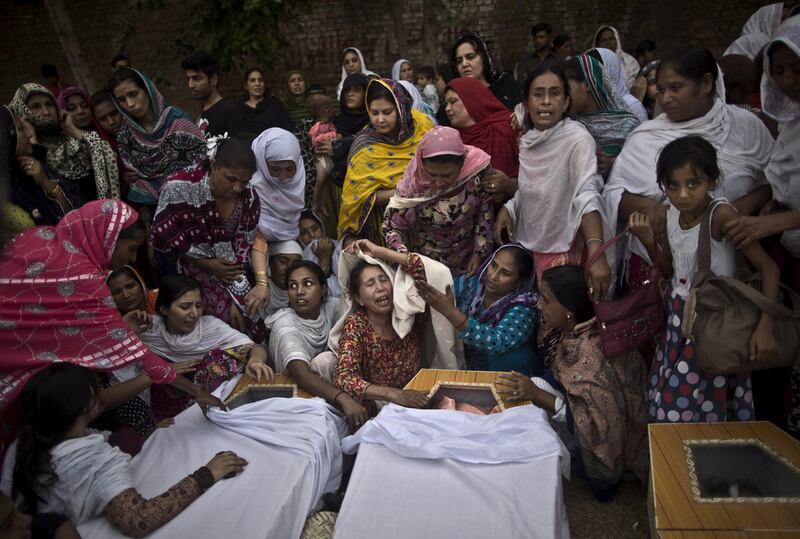 Pakistani women grieve over the coffins of their relatives killed in a suicide attack on a church in Peshawar. Muhammed Muheisen / AP



