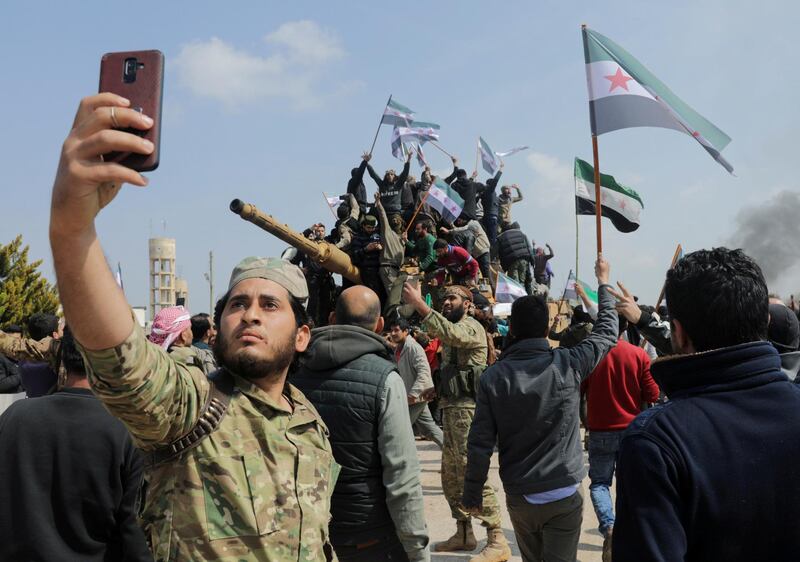 A Turkey-backed Syrian rebel fighter takes a picture with a mobile phone during a protest against the agreement on joint Russian and Turkish patrols, at M4 highway in Idlib province, Syria, March 15, 2020. REUTERS/Khalil Ashawi     TPX IMAGES OF THE DAY