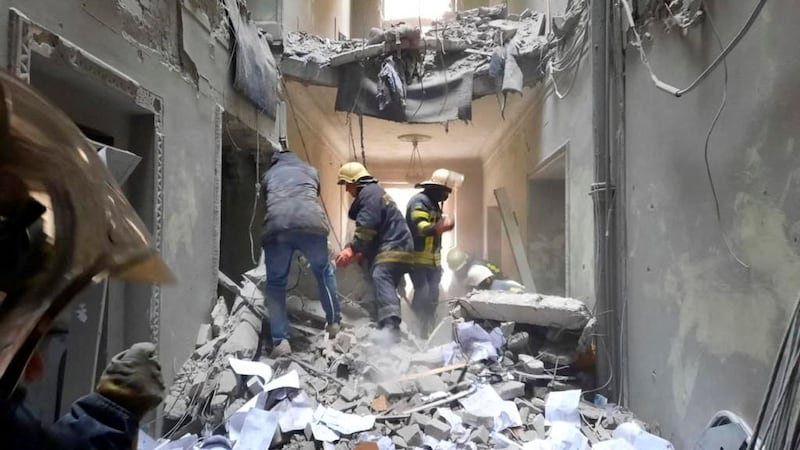 Rescuers in a building damaged by a missile in central Kharkiv. Reuters