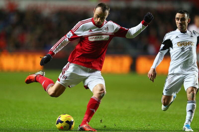 SWANSEA, WALES - JANUARY 28:  Dimitar Berbatov (L) of Fulham shoots asLeon Britton  (R) of Swansea City closes in during the Barclays Premier League match between Swansea City and Fulham at the Liberty Stadium on January 28, 2014 in Swansea, Wales.  (Photo by Michael Steele/Getty Images) *** Local Caption ***  465639885.jpg