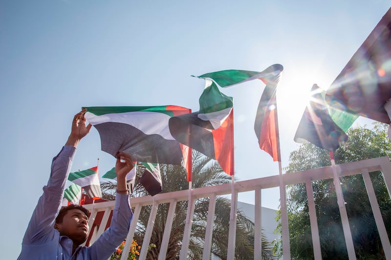 A man arranges the flags at Raffles World Academy in Dubai. Ruel Pableo for The National