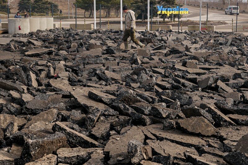 A construction worker walks over rubble at a crossing point between Ukraine and pro-Russian separatist-held territory in Stanytsia Luhanska, Luhansk region, eastern Ukraine. Tensions are high as Russian forces mass on Ukraine's borders. AP Photo