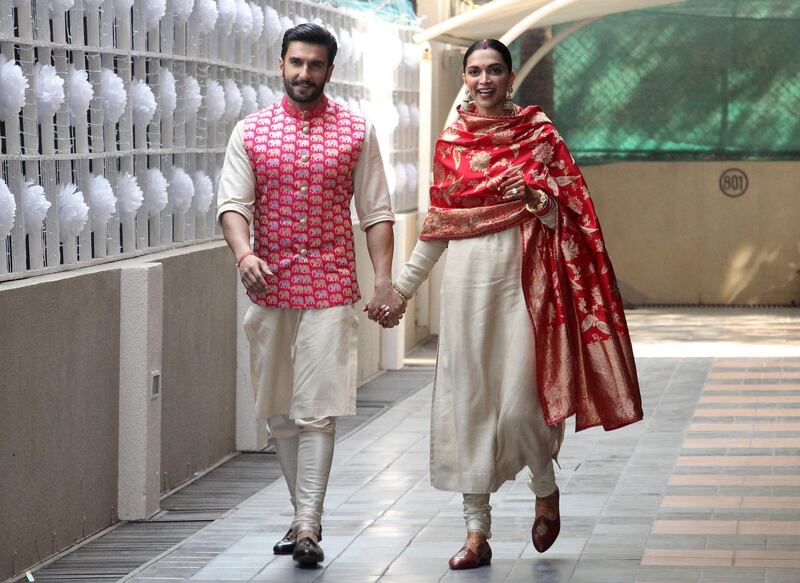 Newly married Bollywood actors Ranveer Singh and Deepika Padukone walk to greet the media at their residence in Mumbai, India. Photo / Reuters
