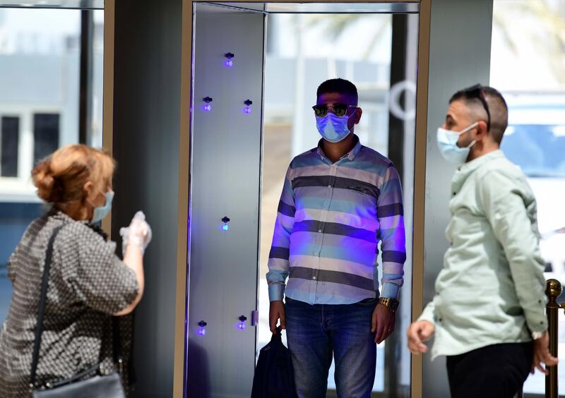 A shopper walks through an infrared medical scanner at a reopened mall in central Baghdad, Iraq. EPA