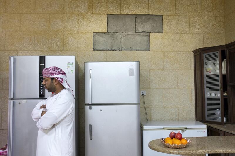 RAS AL KHAIMAH, UNITED ARAB EMIRATES - JANUARY 21, 2019.

Umm Salem's son, Salem Al Mazrouie, stands in his kitchen in Wadi Al Aim. He claims that the tiles in his kitchen have been falling apart due to the powerful blasts from nearby crusher sites. 

(Photo by Reem Mohammed/The National)

Reporter: RUBA HAZA
Section:  NA