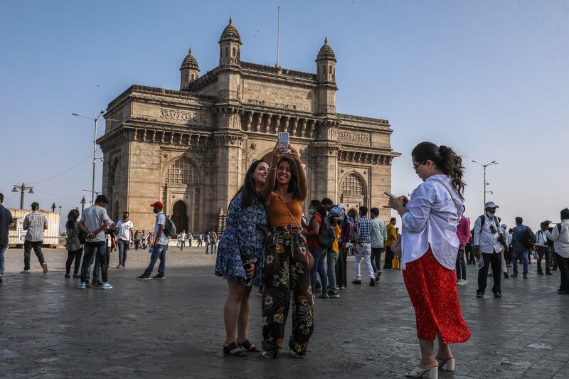 Visitors enjoy leisure time at the Gateway of India, one of Mumbai's main tourist attractions. India’s tourism industry is projected to contribute $512bn to the country's GDP by 2028, according to a government investment agency. EPA