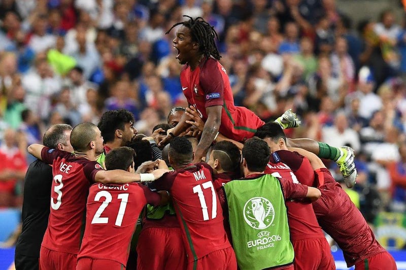 Portugal midfielder Renato Sanches jumps on teammates after Portugal's forward Eder scored the only goal of the match in extra time during the Uefa Euro 2016 Final football match between France and Portugal at the Stade de France in Saint-Denis, north of Paris, on July 10, 2016. Franck Fife / AFP