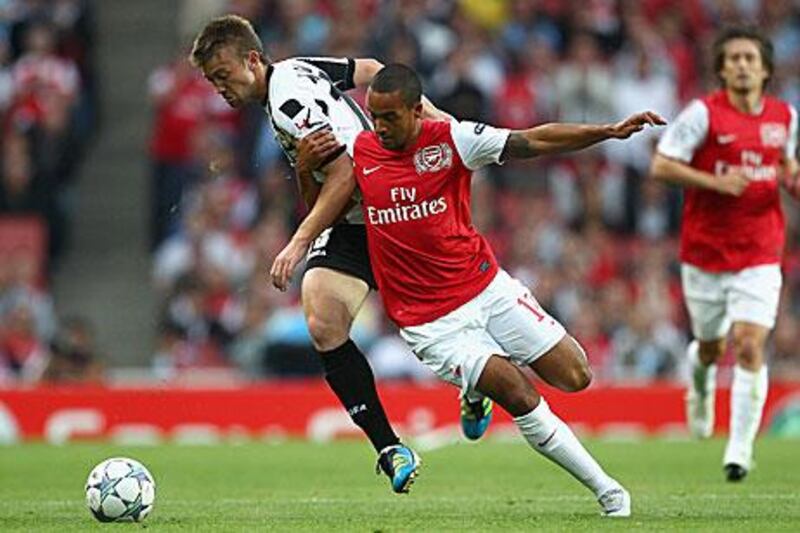 Theo Walcott, right, battles for the ball with Udinese's Neuton. The Arsenal winger's fourth minute goal was about as good as it got for the Premier League club in their 1-0 first-leg win.
