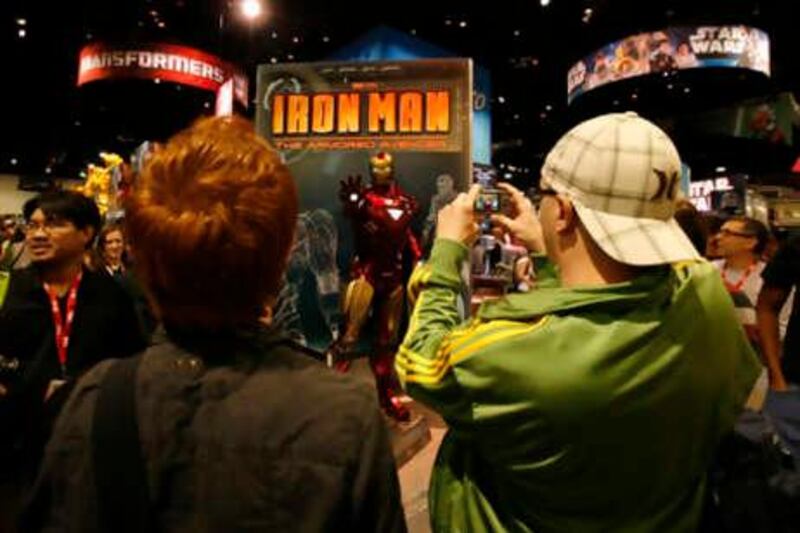 Attendees take photographs of a life size statue of Iron Man while on the convention floor during the opening night of the annual Comic Con in San Diego, California  July 21, 2010.  REUTERS/Mike Blake  (UNITED STATES - Tags: SOCIETY)