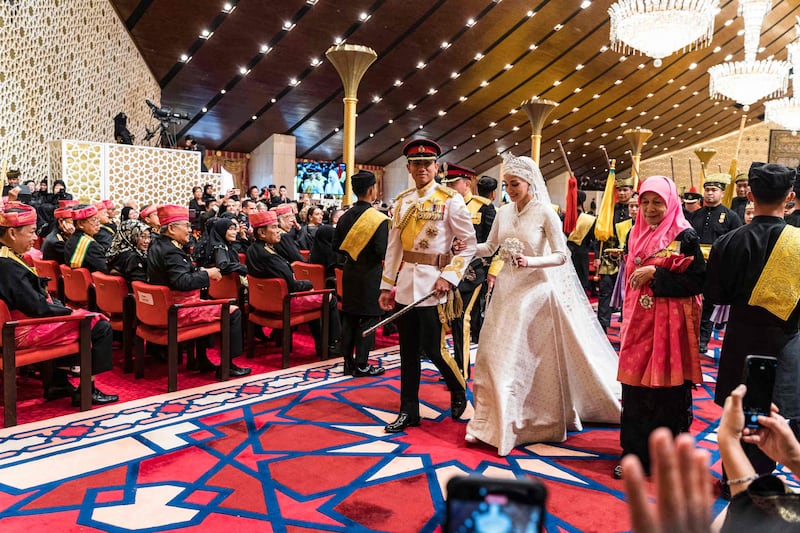 Prince Abdul Mateen and Yang Mulia Anisha Rosnah walk down the aisle during their wedding reception at Istana Nurul Iman in Brunei's capital Bandar Seri Begawan on January 14, 2024.  (Photo by Iqbal Selamat  /  AFP)