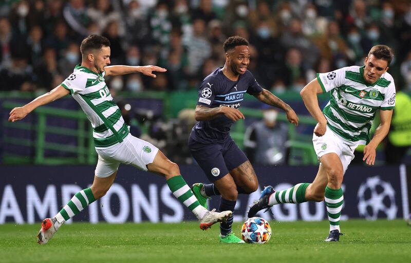 Manchester City's Raheem Sterling takes on Sporting's Pablo Sarabia and Joao Palhinha. Reuters
