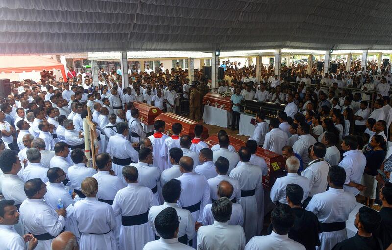 Sri Lankan priests and relatives bless the coffins of bombing victims after a funeral service at St Sebastian's Church in Negombo. AFP