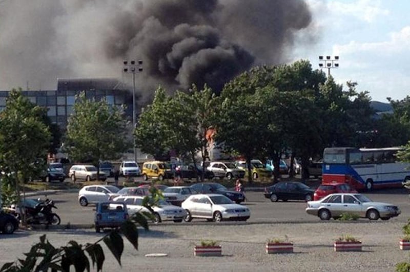 A picture shows smoke rising over Bourgas airport on July 18, 2012. Three people were killed and more than 20 wounded in an apparent bomb attack on a bus packed with Israeli passengers at a Bulgarian airport, officials said, with media saying the toll would rise.  AFP PHOTO / BGNES / BOURGAS INFO (Photo by STR / BGNES / BOURGAS INFO / AFP)