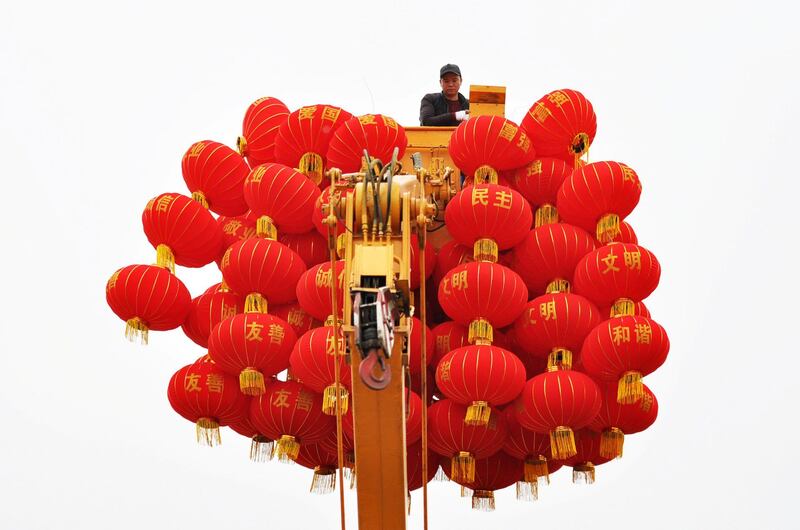 A municipal worker stands on a crane surrounded by red lanterns as he works to put them up ahead of Chinese Lunar New Year in Guiyang, Guizhou province, China. Reuters