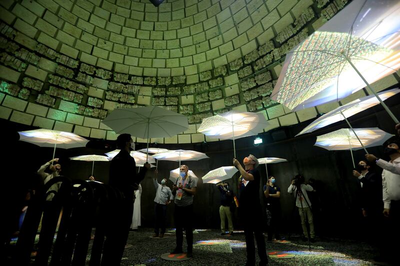 People hold umbrellas as they visit the Netherlands pavilion. Reuters