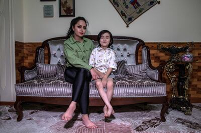 Tattoo artist Soraya Shahidi, 26, sits with her son in her house in West Kabul. 