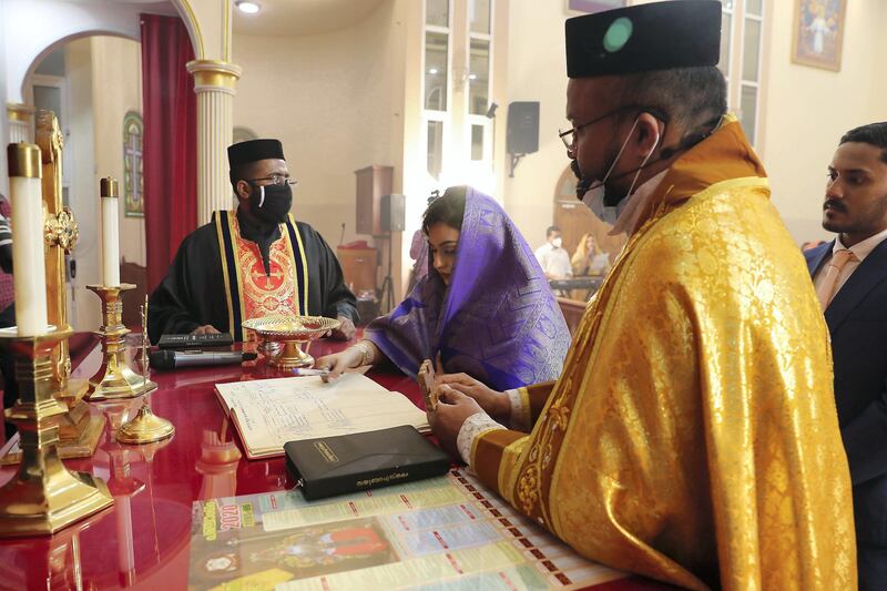 DUBAI, UNITED ARAB EMIRATES , October 26– 2020 :- Jubee Vargheese (bride) and Justin George (groom) during their marriage ceremony held at the St. Thomas Orthodox Cathedral in Dubai. Relatives and friends wearing protective face mask and gloves as a preventive measure against the spread of coronavirus and maintaining social distance during the ceremony.  (Pawan Singh / The National) For News/Online/Instagram. Story by Kelly