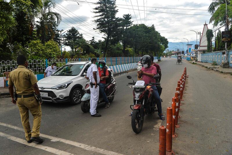 Police check vehicles at a checkpoint during a 15-day partial lockdown, with travel restrictions, imposed to curb the spread of Covid-19 in Siliguri, north-east India. AFP