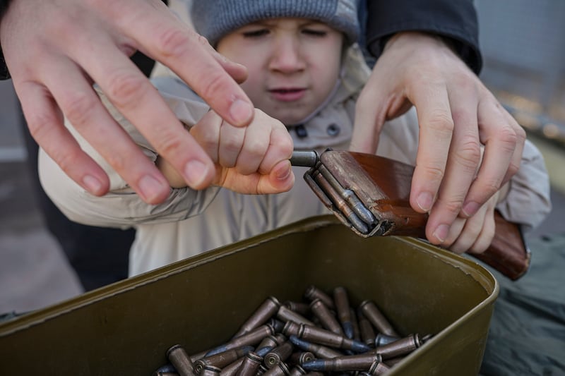 A child tries to remove ammunition from a clip during basic combat training for civilians organised by the National Guard in eastern Ukraine. AP