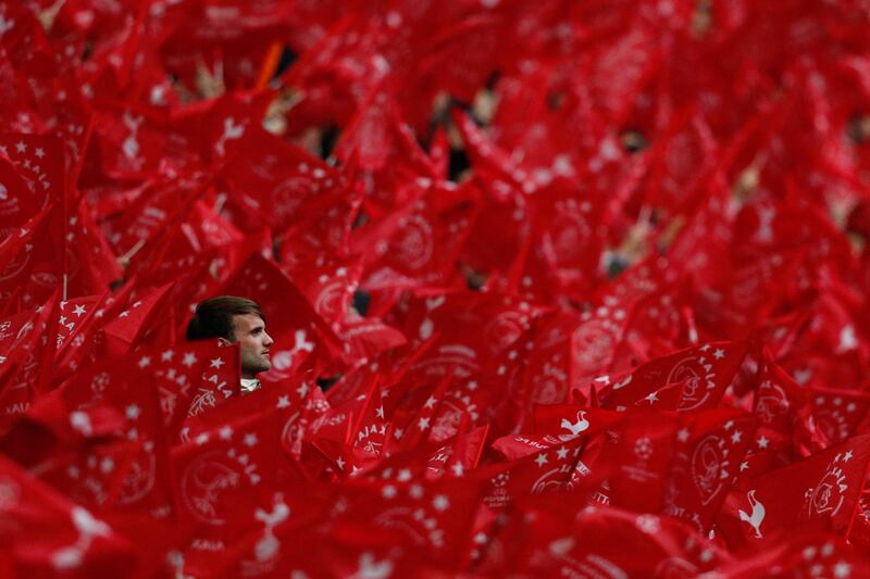 An Ajax supporter is seen through flags from the stands during the UEFA Champions League semi-final second leg football match between the home side and Tottenham Hotspur at the Johan Cruyff Arena, in Amsterdam. AFP