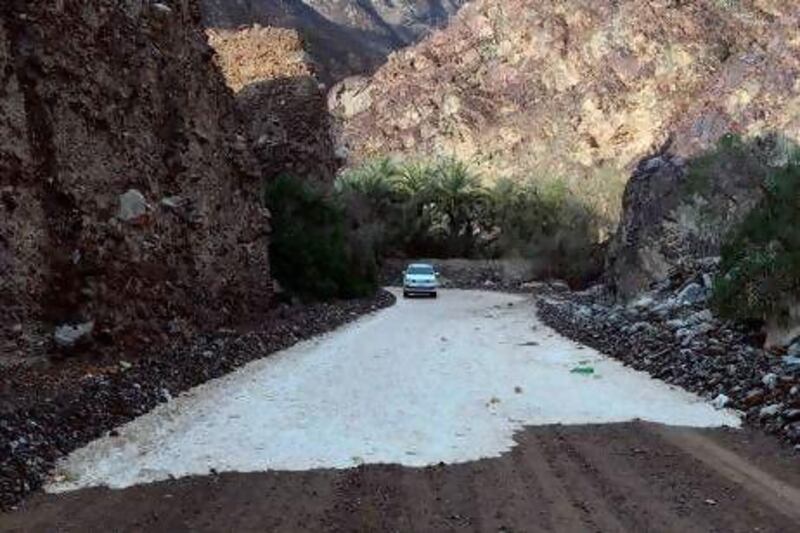 A car negotiates a road following rain in the Northern Emirates.