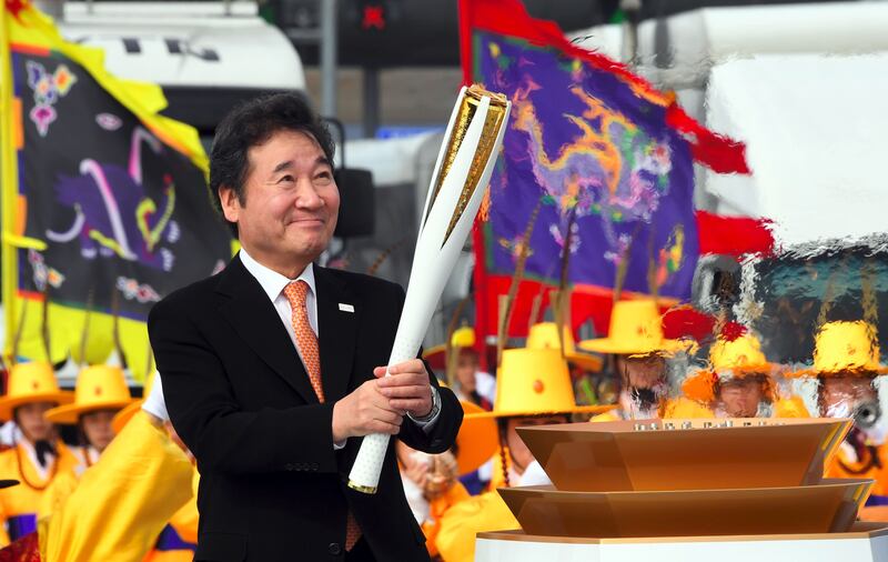 South Korean prime minister Lee Nak-Yon lights the Olympic torch during a ceremony of the start the Olympic torch relay across South Korea at Incheon bridge, west of Seoul, on November 1, 2017. The Olympic flame arrived in South Korea on November 1, 100 days ahead of the opening ceremony for the 2018 Pyeongchang Winter Games.  Jung Yeon-Je / AFP