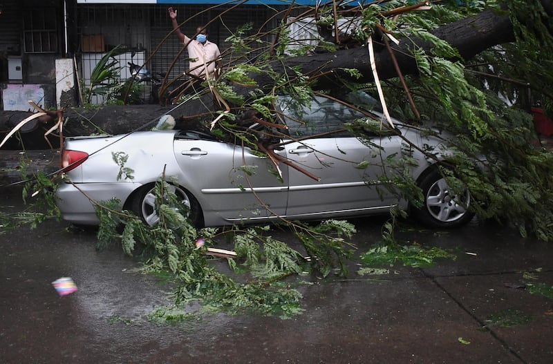A car is left by the roadside after a tree fell on it as cyclone Tauktae blew through Mumbai in India. EPA
