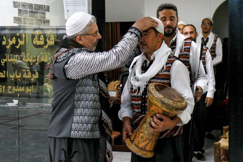 Moutaz Boulad, left, leader of the Bab Al Hara troupe, assists members as they prepare to perform in Amman, Jordan.