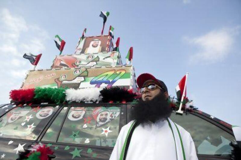 Ahmad Issa, from Pakistan, poses in front of his decorated car as he celebrates the 41st UAE National Day during the Union Car Parade on Yas Island, Abu Dhabi. Silvia Razgova / The National