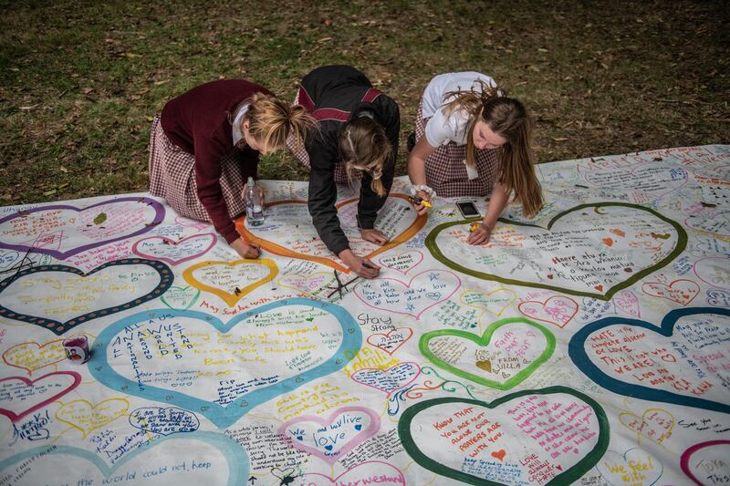CHRISTCHURCH, NEW ZEALAND - MARCH 18: Schoolgirls write messages on a banner during a students vigil near Al Noor mosque on March 18, 2019 in Christchurch, New Zealand. 50 people were killed, and dozens are still injured in hospital after a gunman opened fire on two Christchurch mosques on Friday, 15 March. The accused attacker, 28-year-old Australian, Brenton Tarrant, has been charged with murder and remanded in custody until April 5. The attack is the worst mass shooting in New Zealand's history. (Photo by Carl Court/Getty Images)