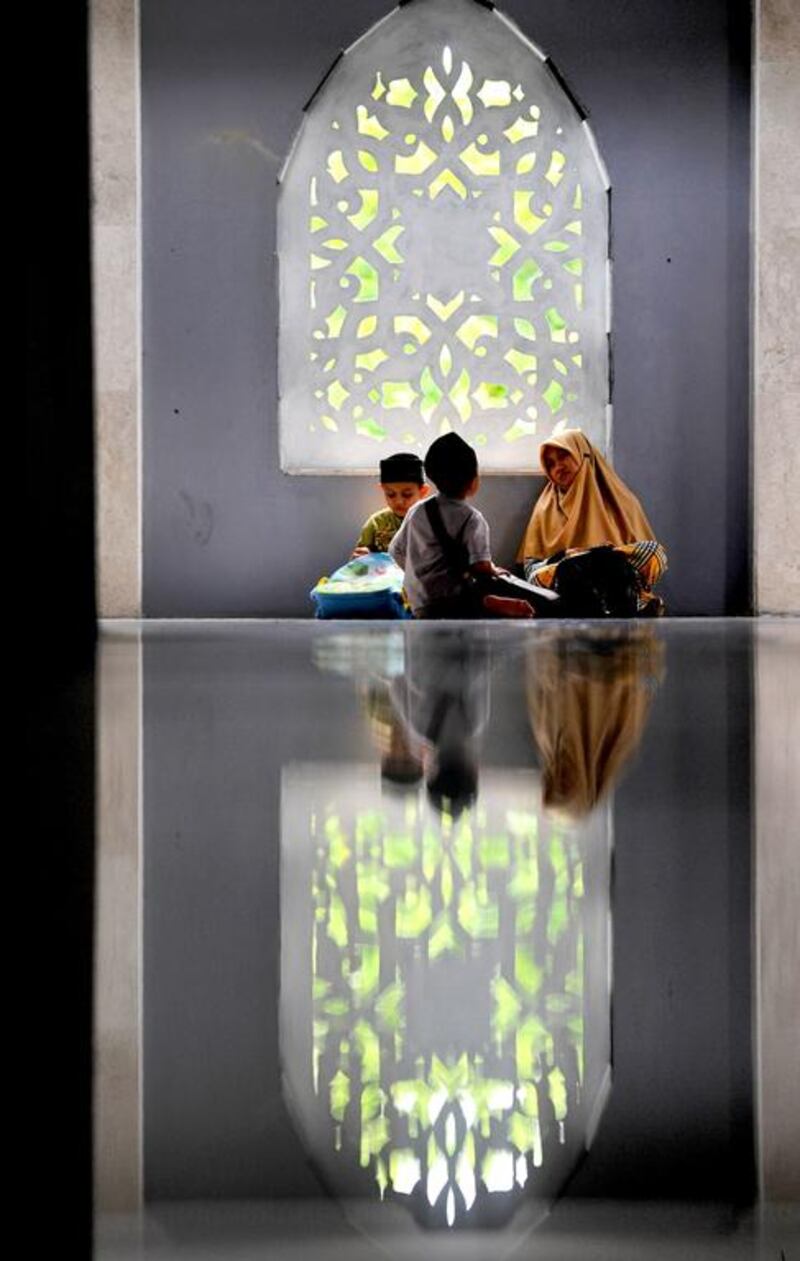 Young Indonesian Muslims wait for Mahgrib prayers a mosque in Banda Aceh. Chaibeer Mahyuddin / AFP Photo