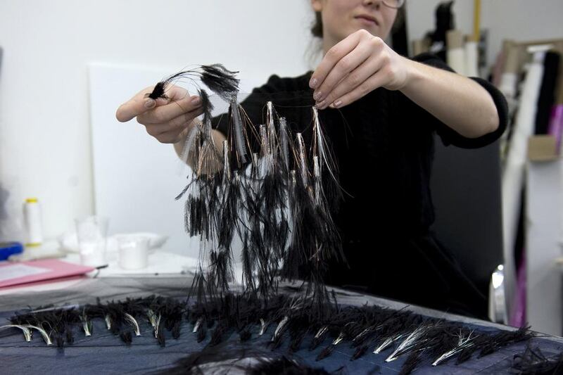 At the Lemarié Ateliers, the ostrich feathers are attached to the lurex fringes and applied to the tulle of the overskirt — with the help of a pair of pliers and a dot of glue. (Courtesy: Chanel)