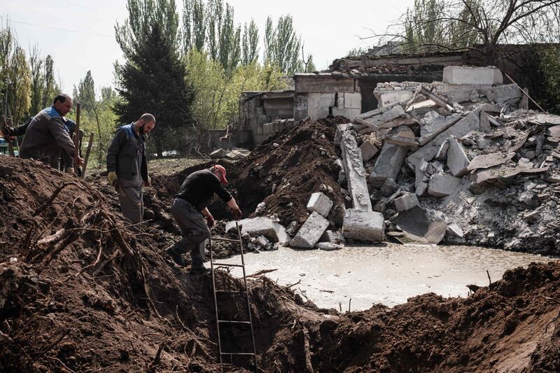 Ukrainian men at the site of a missile explosion in Kramatorsk, eastern Ukraine. AFP