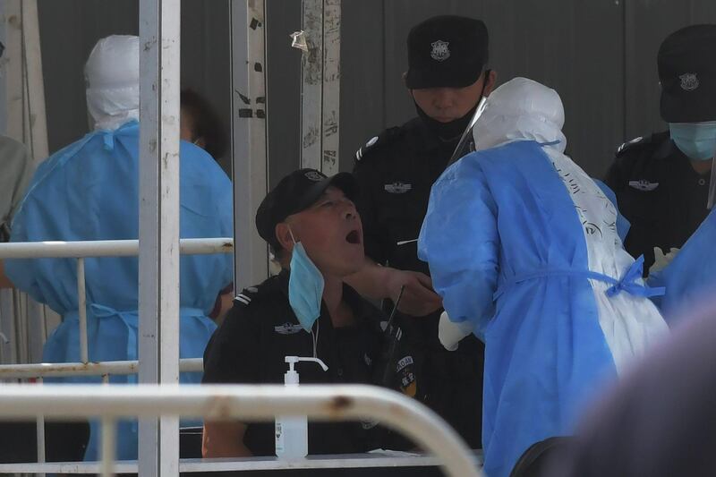 A security guard is swabbed a testing station in Beijing. AFP