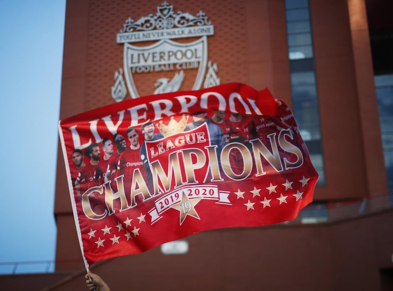 Fans celebrate outside Anfield stadium after Liverpool were crowned champions on Thursday evening. EPA