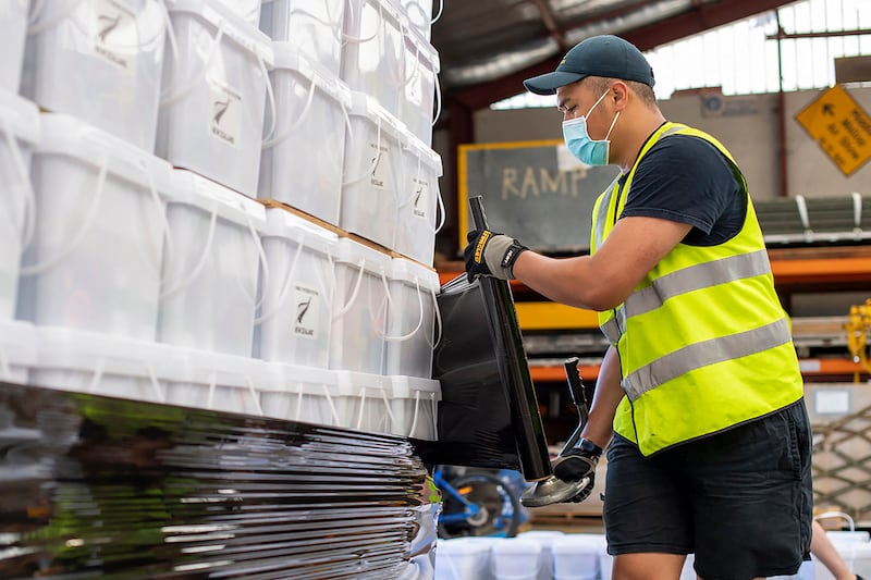 A relief worker in New Zealand stacks disaster relief supplies to be taken to Tonga by the country's air force.  AFP
