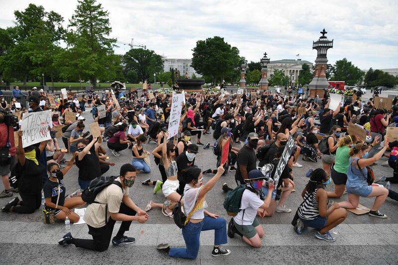 Protesters kneel to demonstrate against the death of George Floyd near the US Capitol, in Washington, DC. AFP