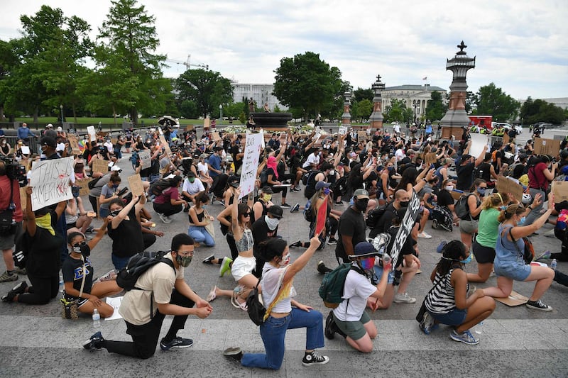 Protesters kneel to demonstrate against the death of George Floyd near the US Capitol, in Washington, DC. AFP