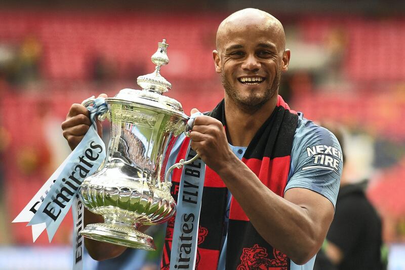 Manchester City's Belgian captain Vincent Kompany holds the winner's trophy after the English FA Cup final football match between Manchester City and Watford at Wembley Stadium in London, on May 18, 2019. - Manchester City beat Watford 6-0 at Wembley to claim the FA Cup. (Photo by Daniel LEAL-OLIVAS / AFP) / NOT FOR MARKETING OR ADVERTISING USE / RESTRICTED TO EDITORIAL USE