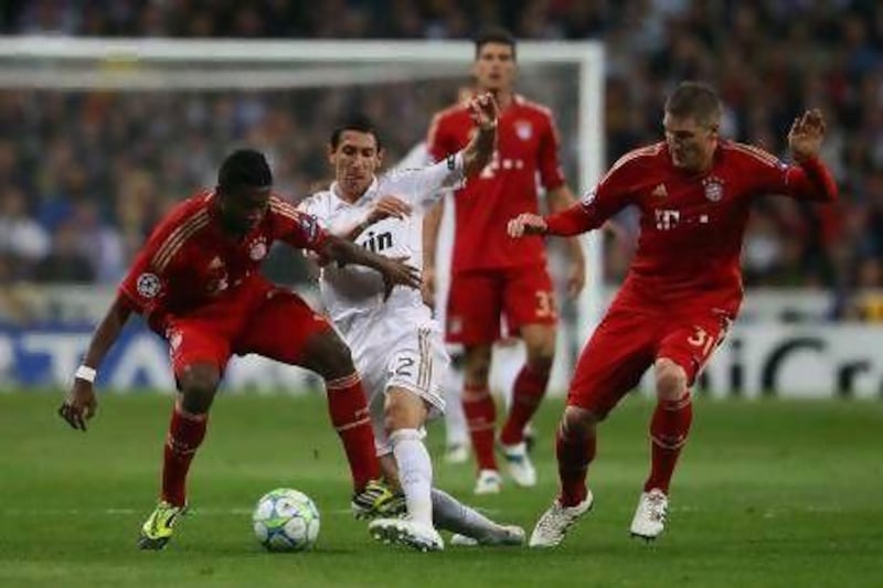 Bayern Munich's David Alaba, left, and Bastian Schweinsteiger, right, rob Real's Angel Di Maria of the ball last night. Christof Koepsel / Getty Images