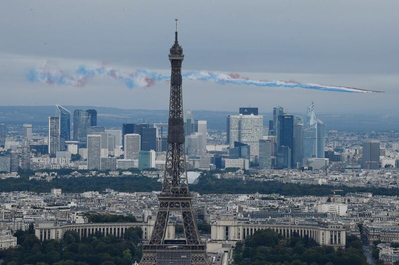 Planes from the French Acrobatic Patrol, spray lines of red, white and blue smoke, the colours of the French flag fly, over the Eiffel Tower. EPA