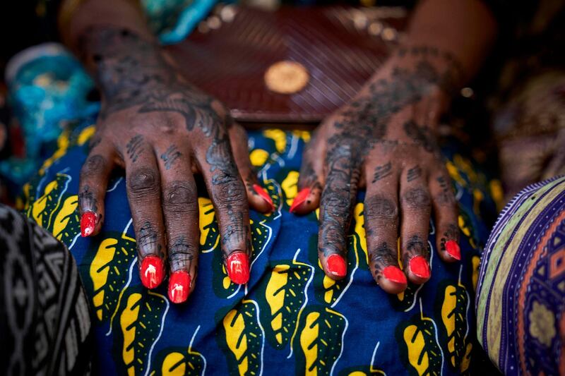 A Malian woman poses with her henna decorated hands and painted fingernails, on the eve of Eid Al Adha, in Bamako.AFP