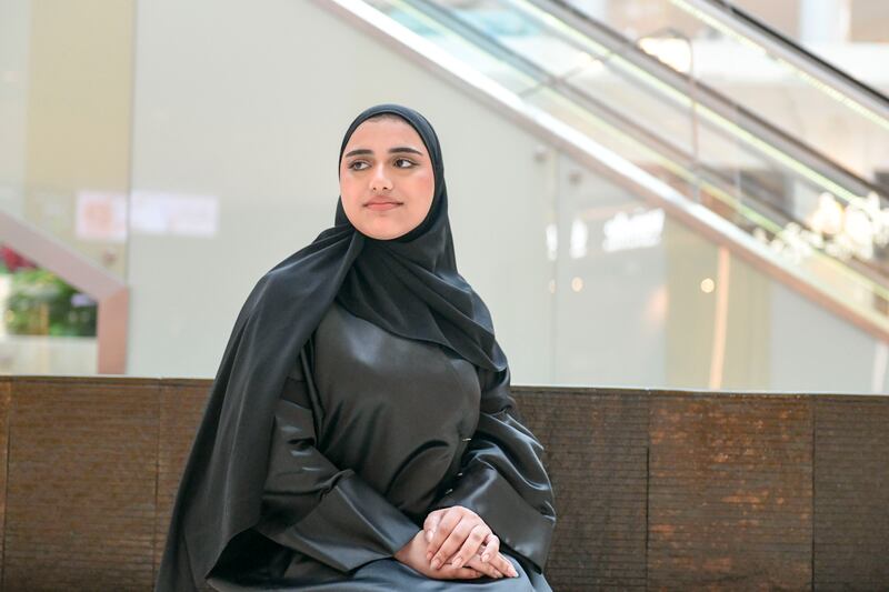 Mouza Al Hammadi works as a cashier at a supermarket in Abu Dhabi. Khushnum Bhandari / The National
