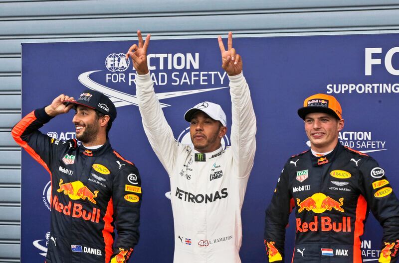 Pole position winner Mercedes driver Lewis Hamilton of Britain, center, celebrates flanked by third placed Red Bull driver Daniel Ricciardo of Australia, left, and second placed Red Bull driver Max Verstappen of the Netherlands at the end of the qualifying session for Sunday's Italian Formula One Grand Prix, at the Monza racetrack, Italy, Saturday, Sept.2, 2017. (AP Photo/Luca Bruno)